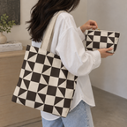 Woman carrying the brown cream triangle tote bag with the matching makeup bag in her hand