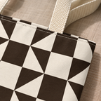Close-up of the brown and cream triangle print and the beige handle of the tote bag