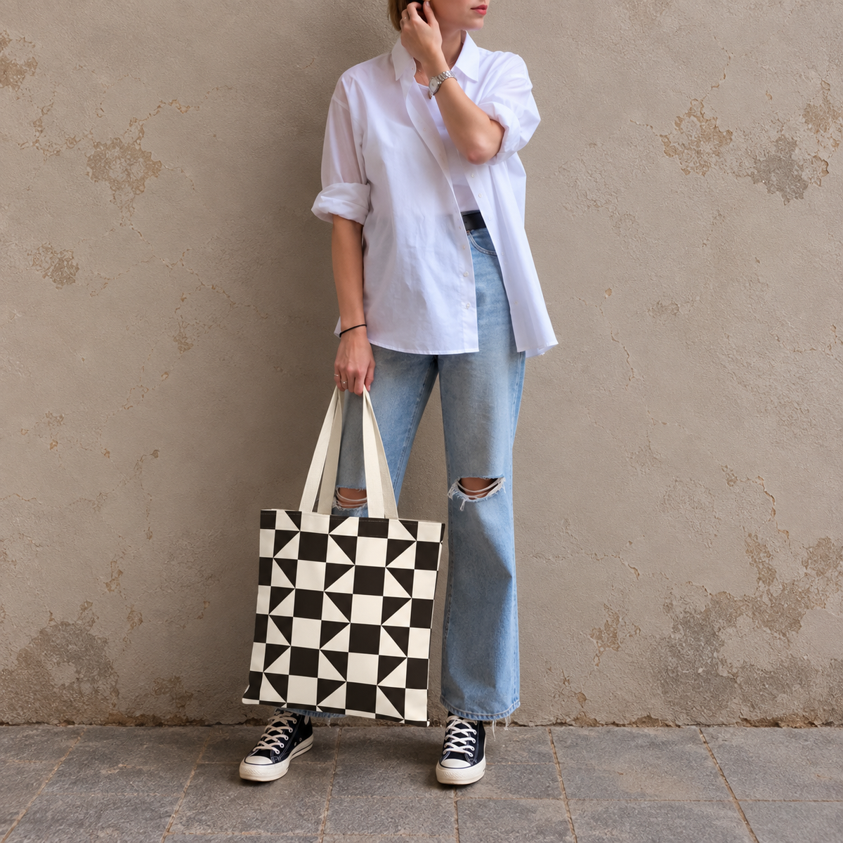 Woman in white shirt and jeans standing with the brown cream triangle tote bag