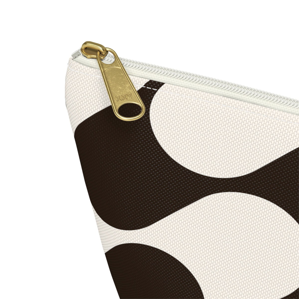 Close-up of the gold zipper pull and brown wave print on the makeup bag