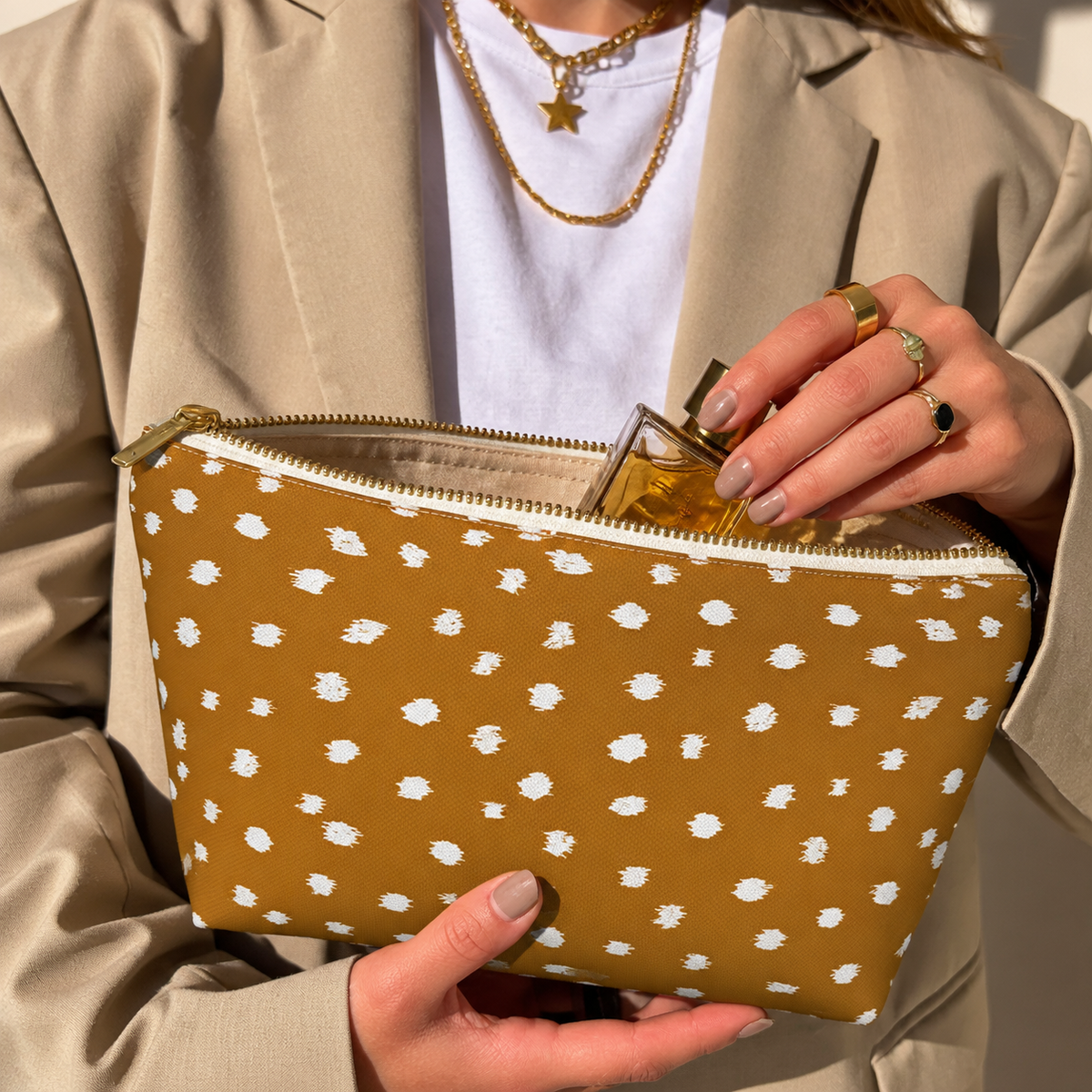 Hands holding the open Brown Fawn Spotted makeup bag