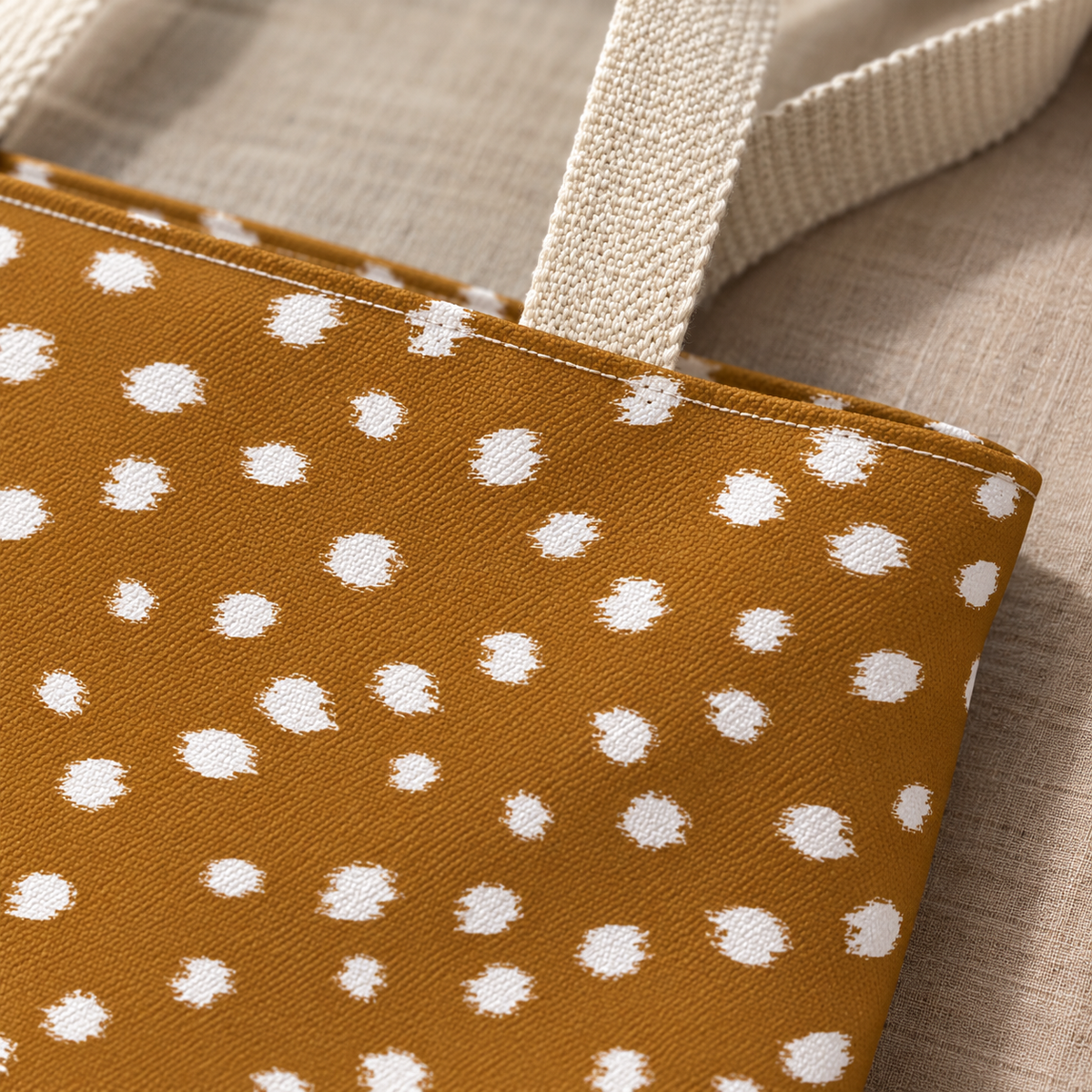 Close-up of the white fawn spots on caramel brown and the cream handle of the tote bag