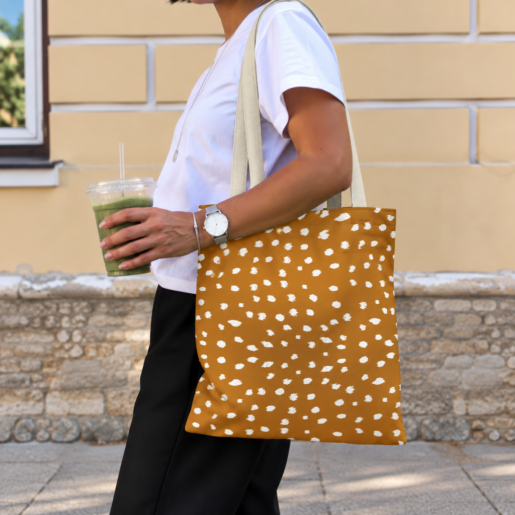 Woman carrying the Brown Fawn Spotted tote bag, side view with an iced drink