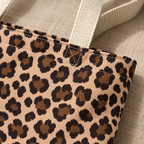 Close-up of the brown leopard print rosettes and cream handle of the tote bag