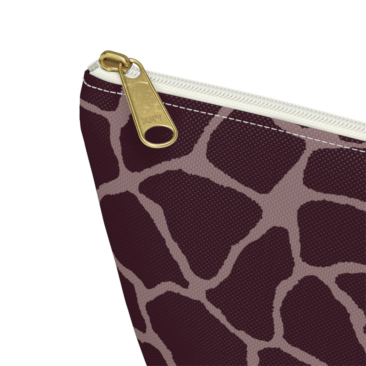 Close-up of the gold zipper pull and pink giraffe lines on the makeup bag