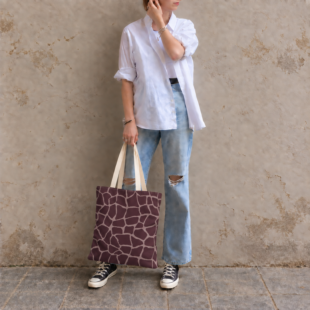 Woman leaning on a wall with a giraffe print tote bag in brown and pink