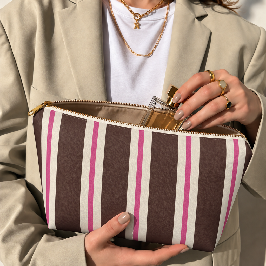 Hands holding the open brown pink striped makeup bag