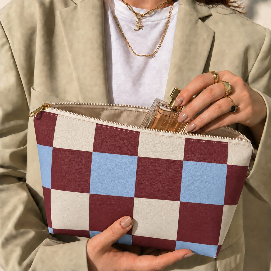 Hands holding the open burgundy blue cream checkered makeup bag