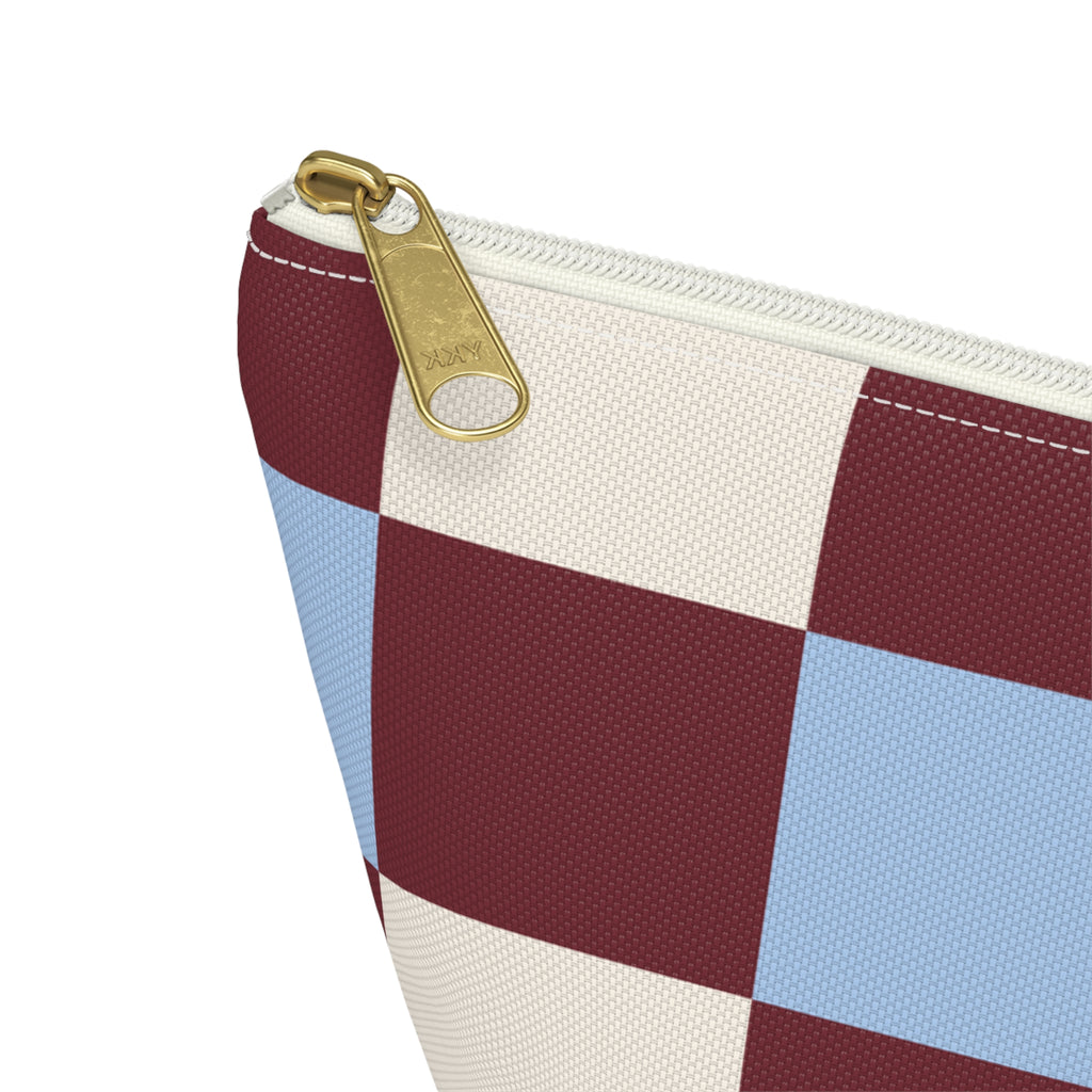 Close-up of the gold zipper pull and checkered squares on the makeup bag