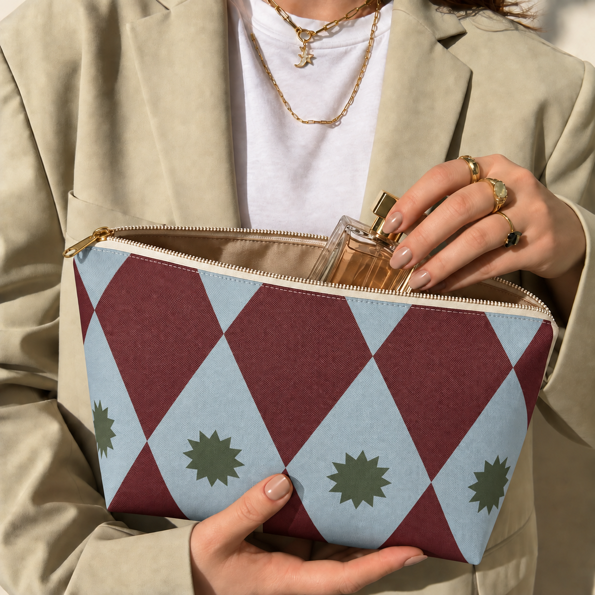 Model opening the burgundy blue diamond makeup bag to take out a perfume bottle