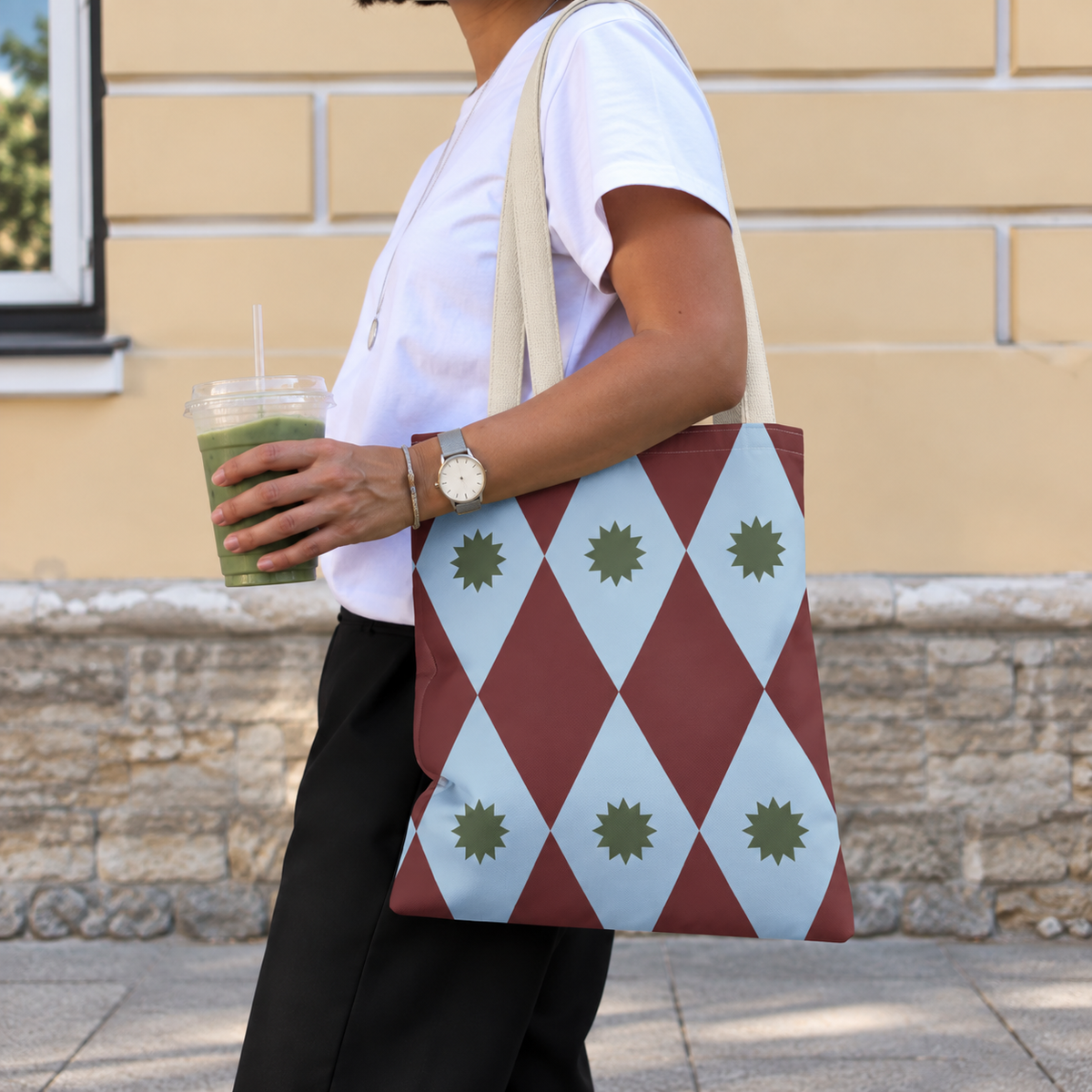 Side view of a model carrying the diamond tote bag in burgundy and powder blue