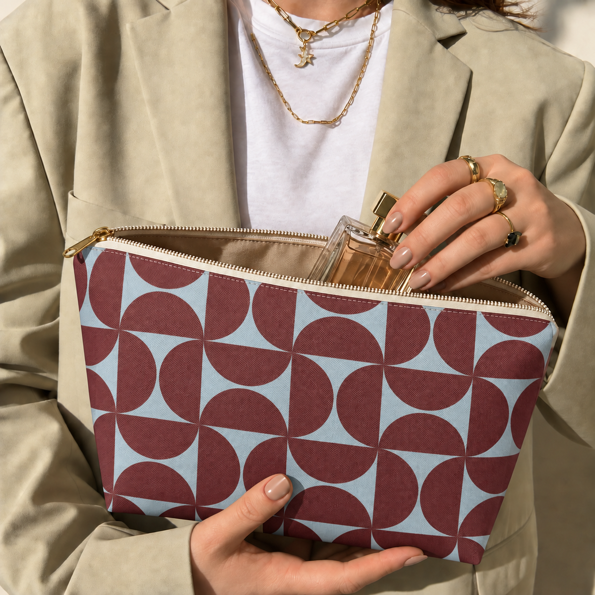 Hands holding the open burgundy blue geometric makeup bag