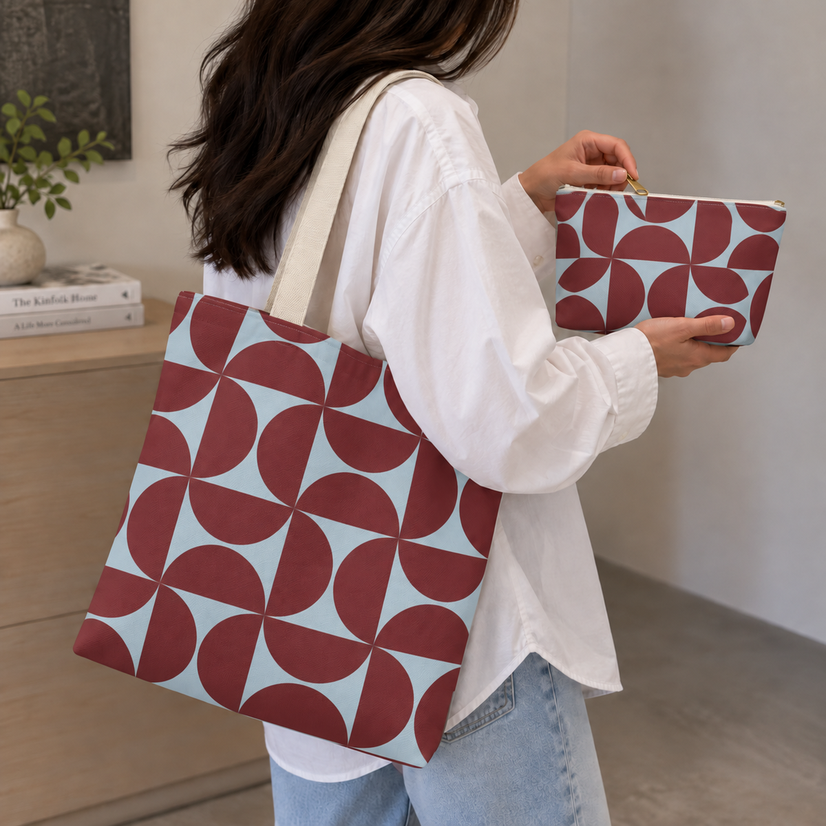 Woman carrying the burgundy blue geometric tote bag and holding the matching makeup bag