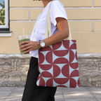 Side view of a person carrying the burgundy blue geometric tote bag on the shoulder