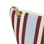Close-up of the gold zipper pull and burgundy and blue pinstripes on the makeup bag