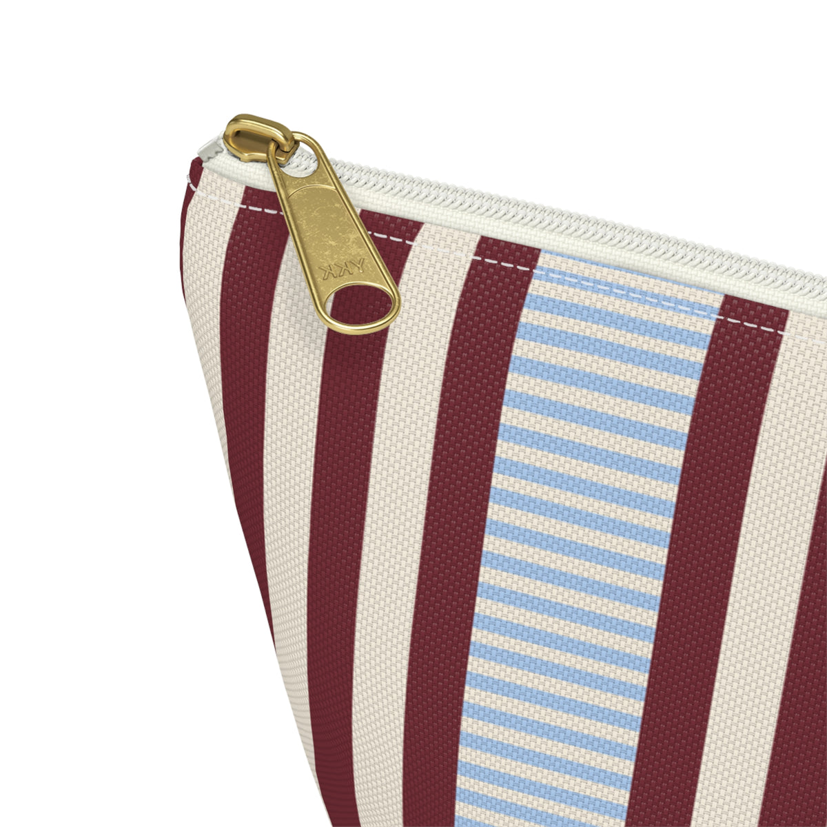 Close-up of the gold zipper pull and burgundy and blue pinstripes on the makeup bag