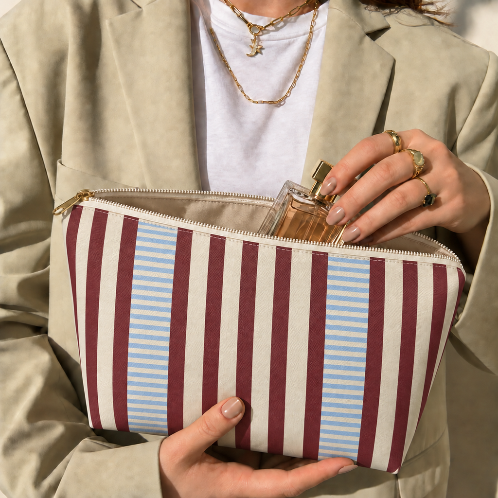 Hands holding the open burgundy blue pinstripe makeup bag