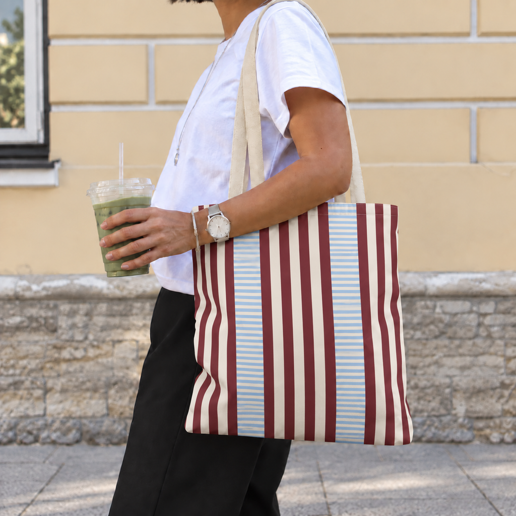 Woman carrying the burgundy blue pinstripe tote bag on her shoulder on the street