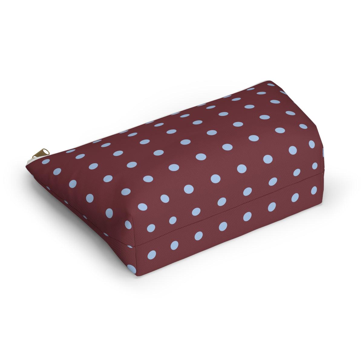 Burgundy cosmetic bag with light blue polka dots lying at an angle