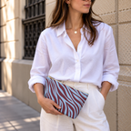 Woman in a white shirt holding the burgundy blue zebra print makeup bag at her hip