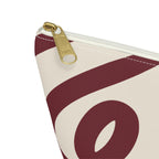 Close-up of the gold zipper pull and burgundy loop print on the makeup bag