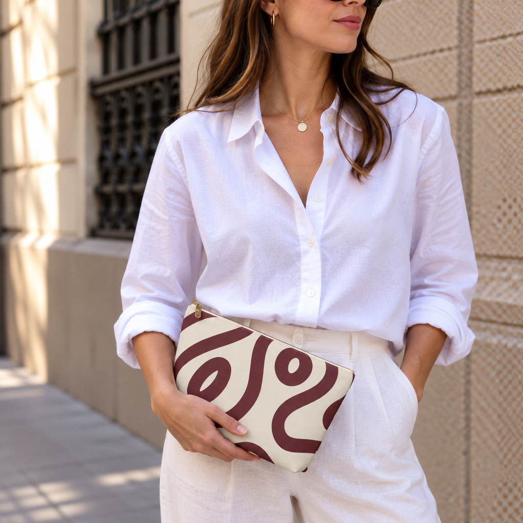 Woman in white shirt holding the burgundy cream abstract makeup bag