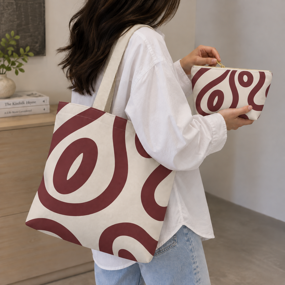Woman carrying the burgundy cream abstract tote bag with the matching makeup bag in her hand