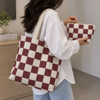 Woman carrying the burgundy checkered tote bag and holding the matching makeup bag