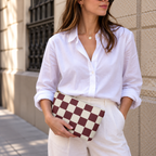 Woman in white shirt holding the burgundy cream checkered makeup bag