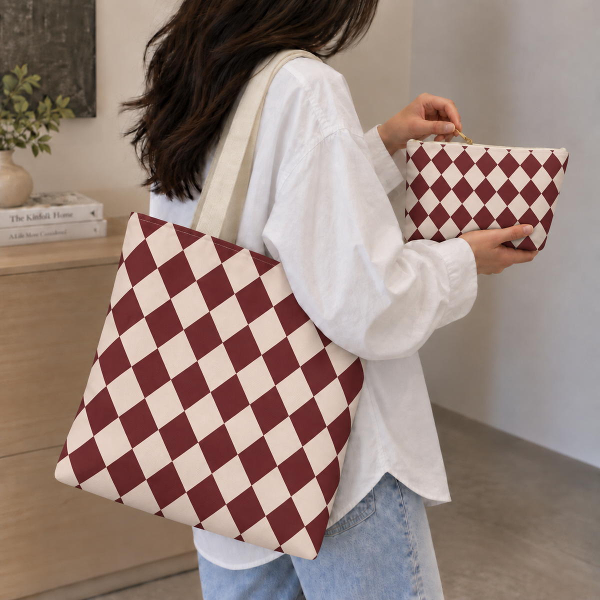 Woman carrying a burgundy diamond checkered tote bag and matching makeup bag