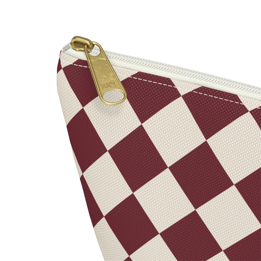 Close-up of the gold zipper pull and burgundy cream diamonds on the makeup bag