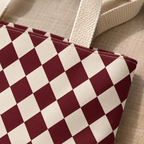 Close-up of burgundy and cream diamonds and the tote bag handle