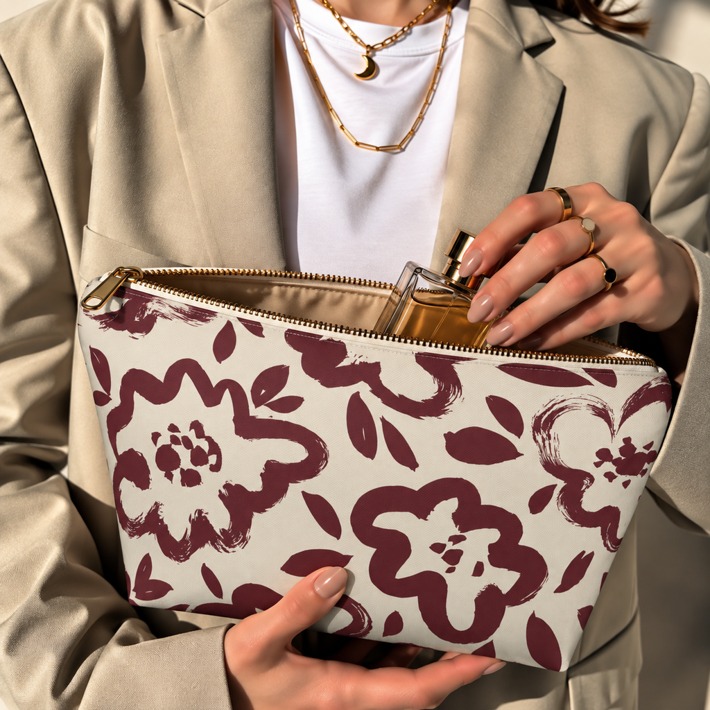 Hands holding the open burgundy cream floral makeup bag