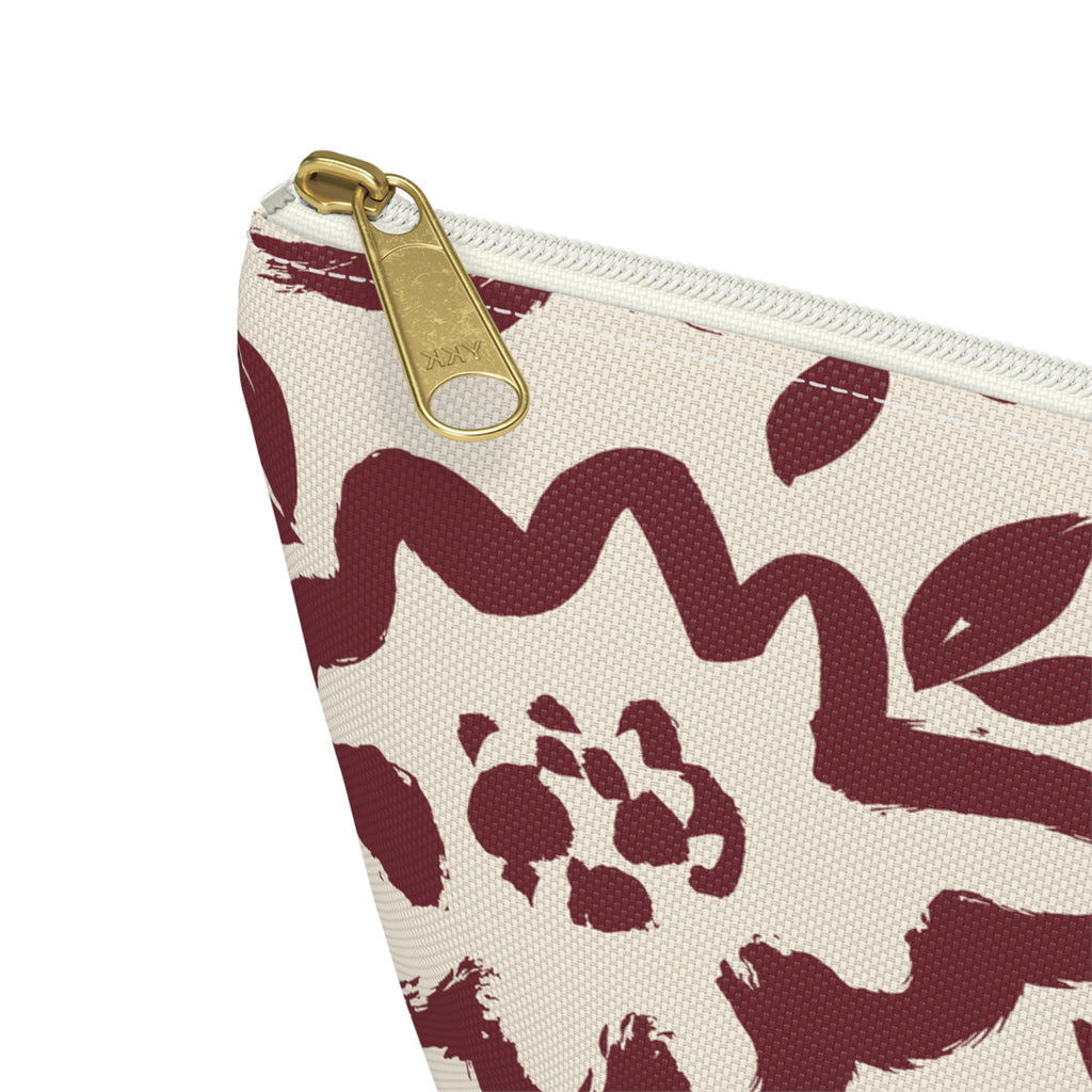 Close-up of the gold zipper pull and burgundy flower print on the makeup bag