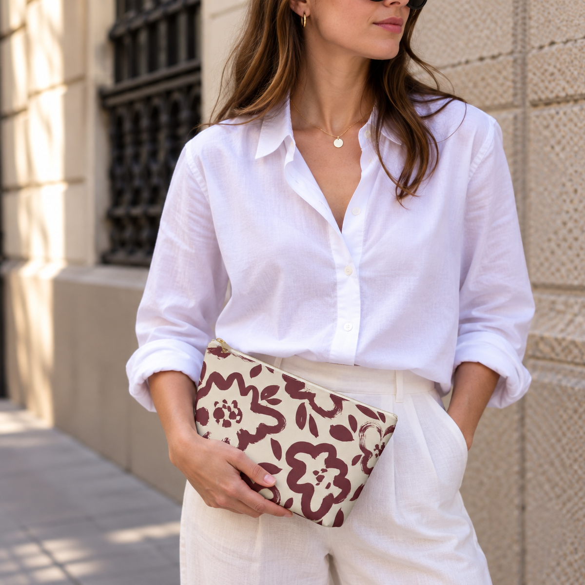 Woman in white shirt holding the burgundy cream floral makeup bag