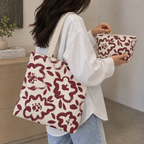 Woman carrying the burgundy floral tote bag with the matching floral makeup bag in her hand