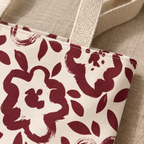 Close-up of the burgundy flower print and beige handle of the floral tote bag