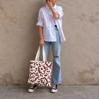 Woman in white shirt and jeans standing with the burgundy cream floral tote bag