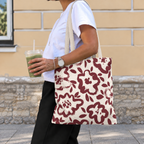 Side view of a person carrying the burgundy cream floral tote bag on the shoulder