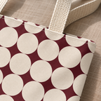 Close-up of the cream circle and burgundy diamond print and handle of the geometric tote bag