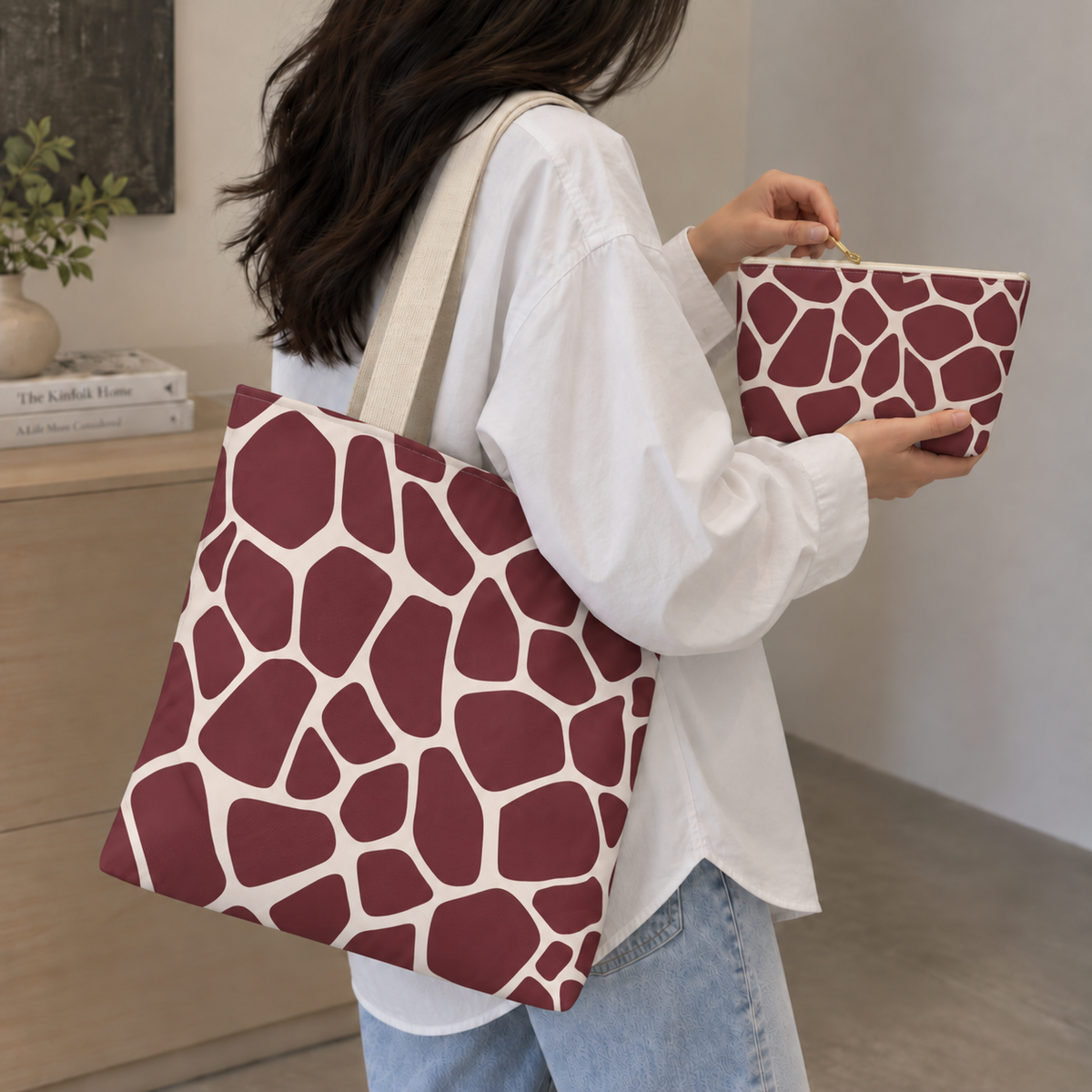 Woman carrying a burgundy giraffe print tote bag and matching makeup bag