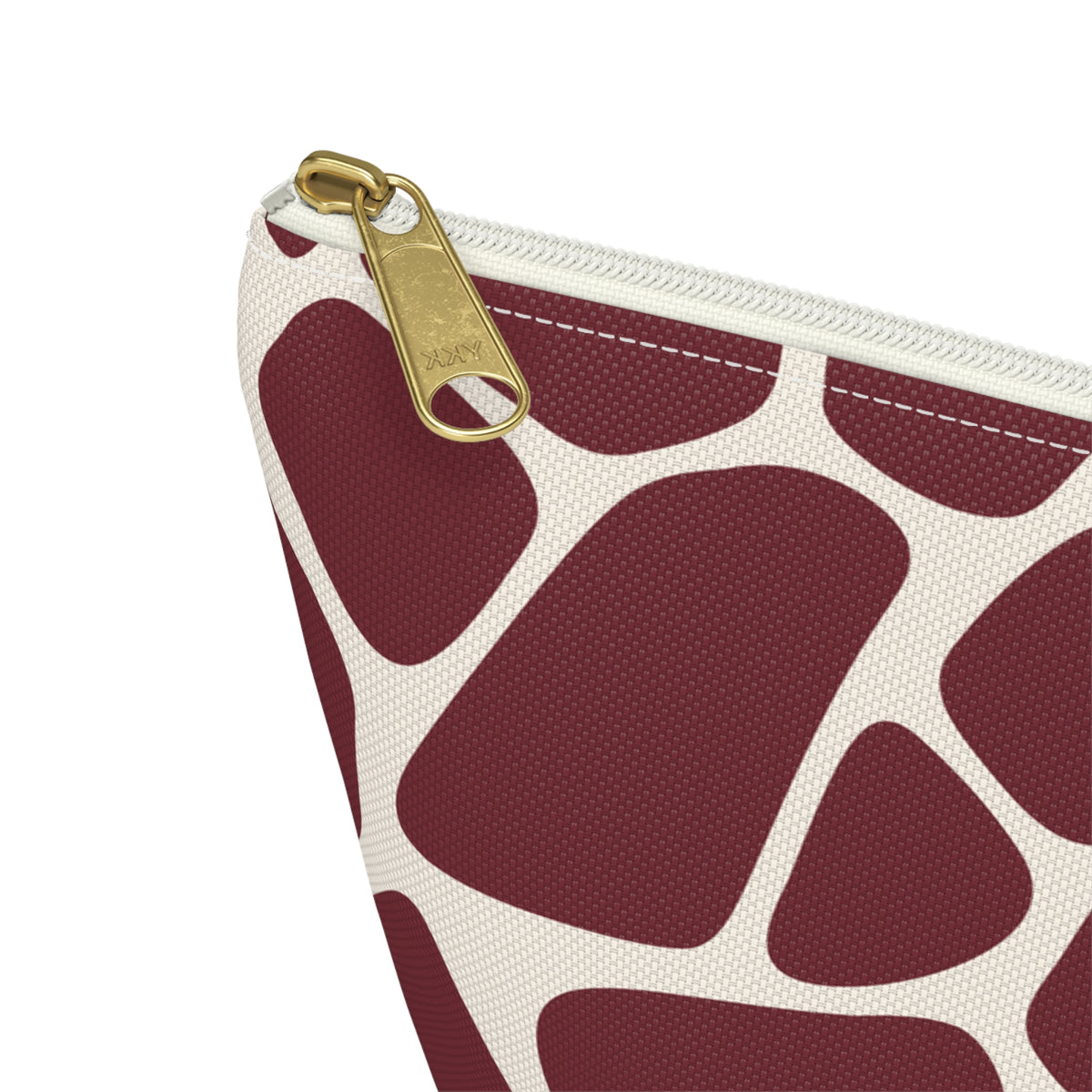 Close-up of the gold zipper pull and burgundy giraffe patches on the makeup bag