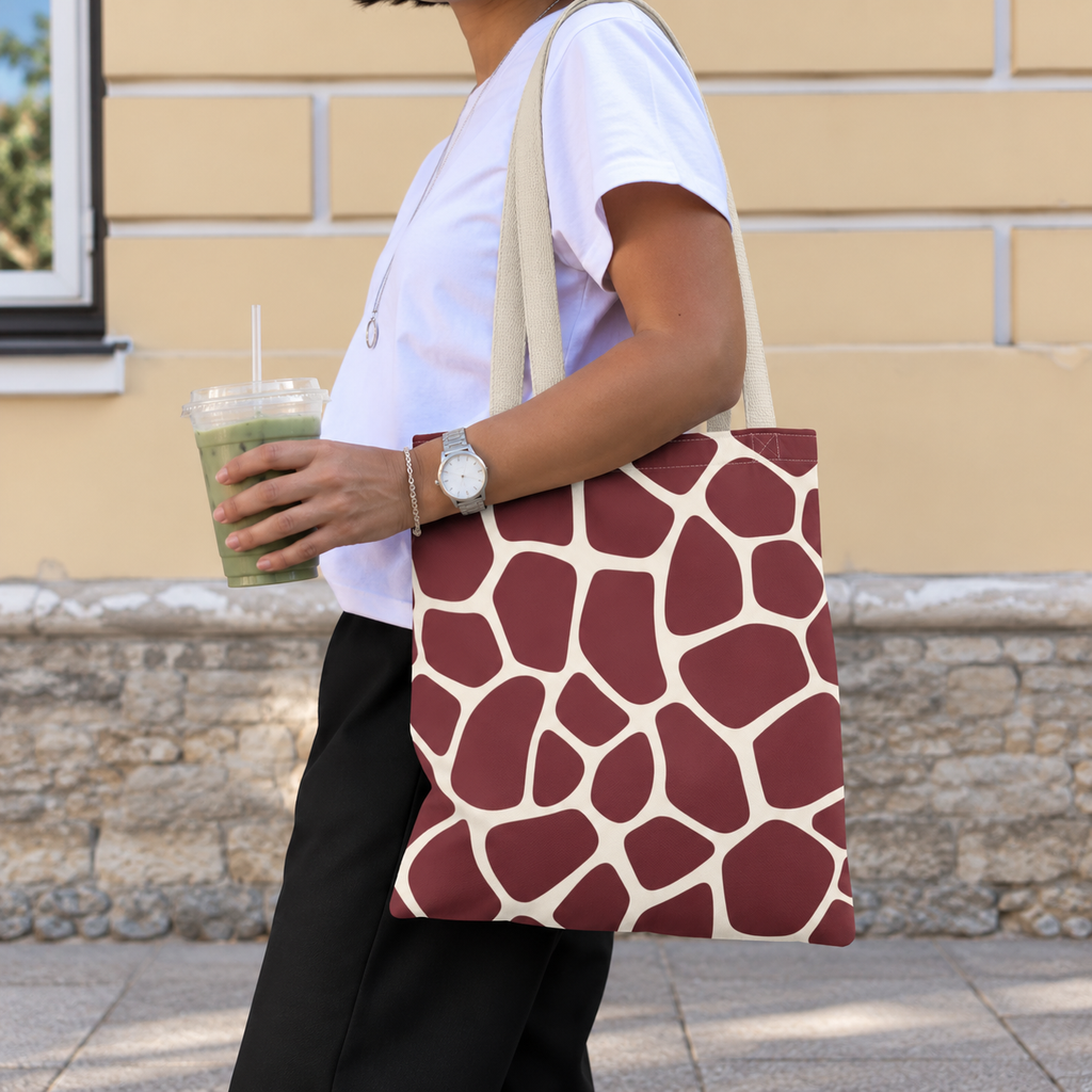 Woman walking with a burgundy cream giraffe print tote bag over her shoulder