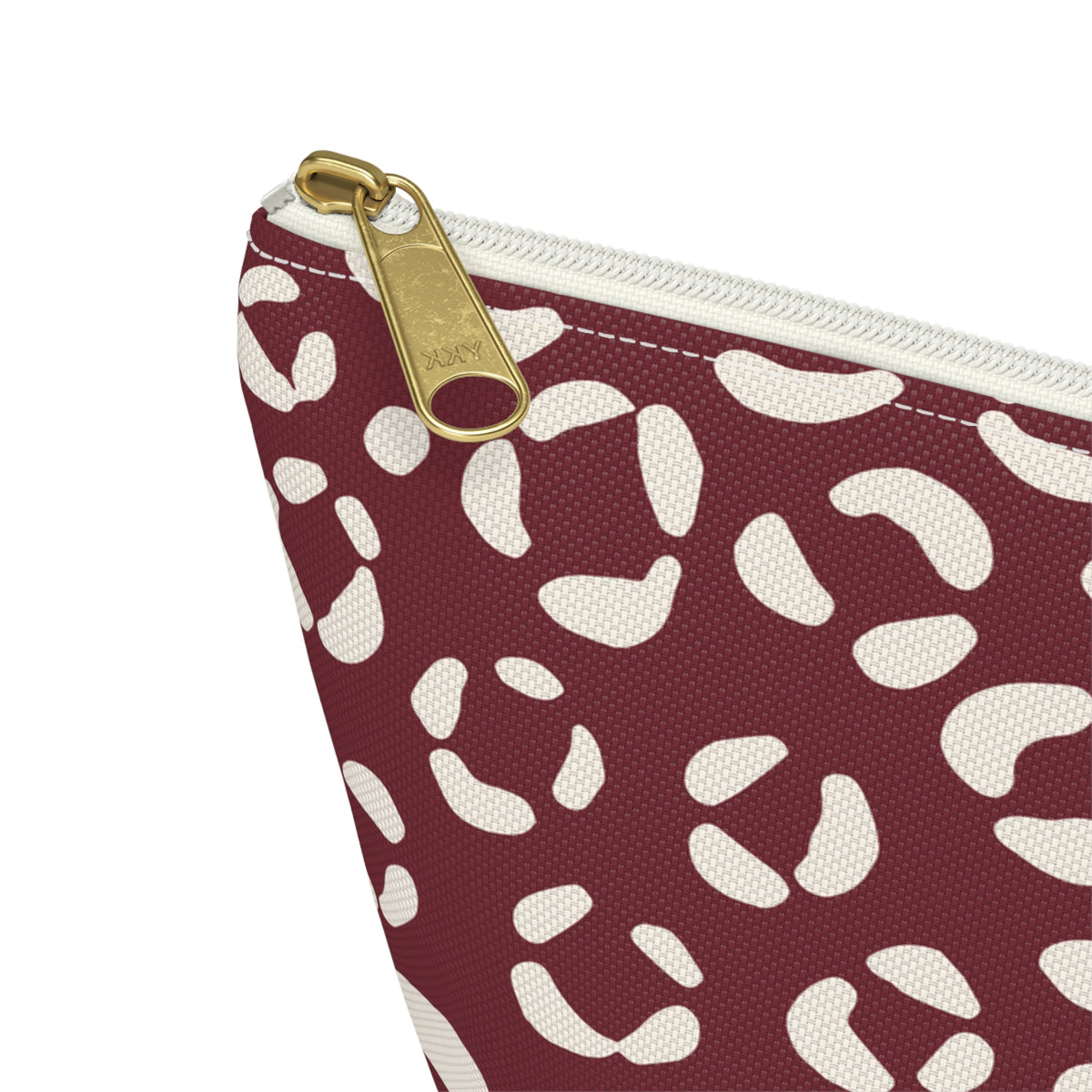 Close-up of the gold zipper pull and cream leopard spots on the makeup bag