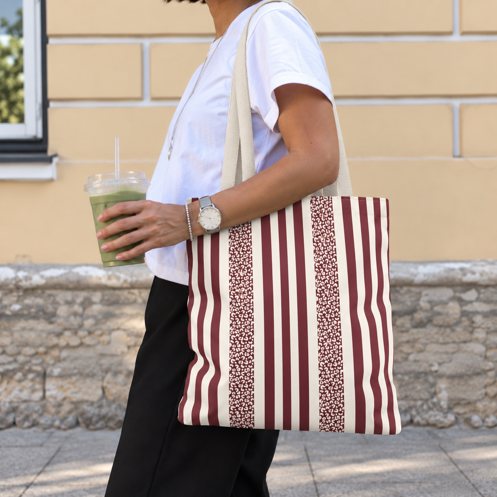 Side view of a woman carrying a burgundy cream leopard striped tote bag