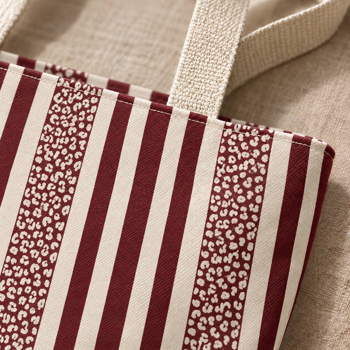 Close-up of burgundy stripes and small leopard spot panel next to the tote bag handle