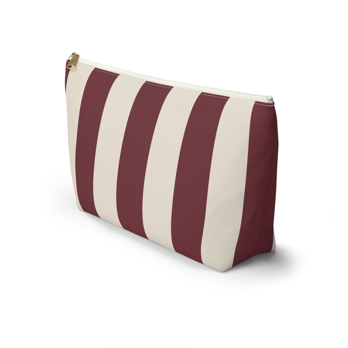 Side view of the burgundy cream striped makeup bag standing on a white background