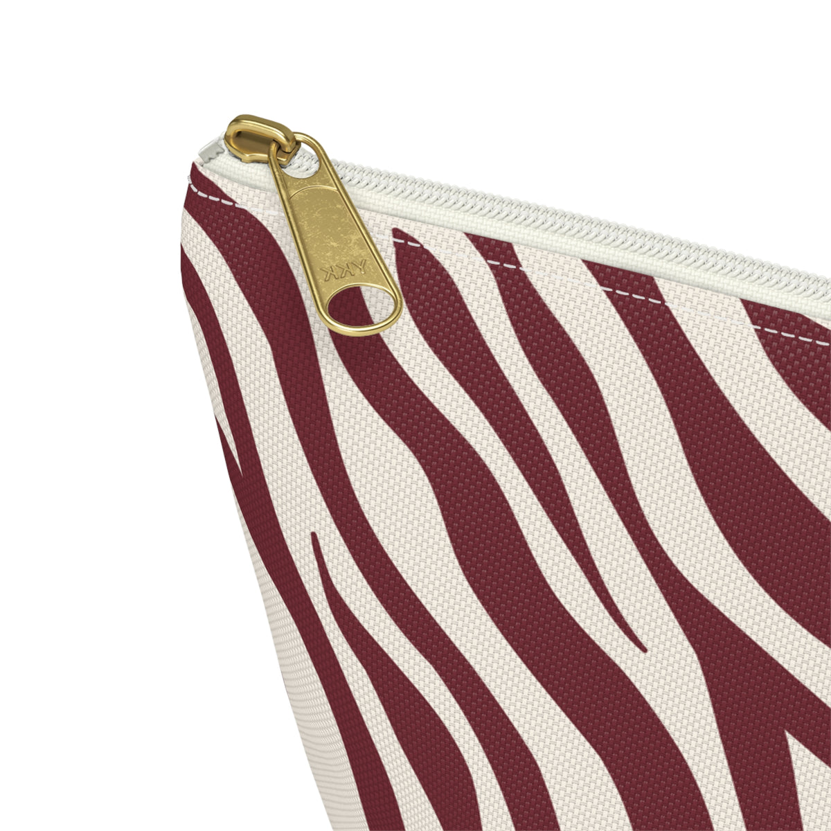 Close-up of the gold zipper pull on the burgundy cream zebra print makeup bag