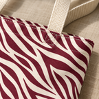Close-up of the burgundy zebra stripes and cream handle of the tote bag