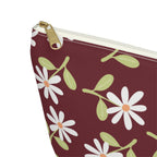 Close-up of the gold zipper pull and white daisy print on the burgundy makeup bag
